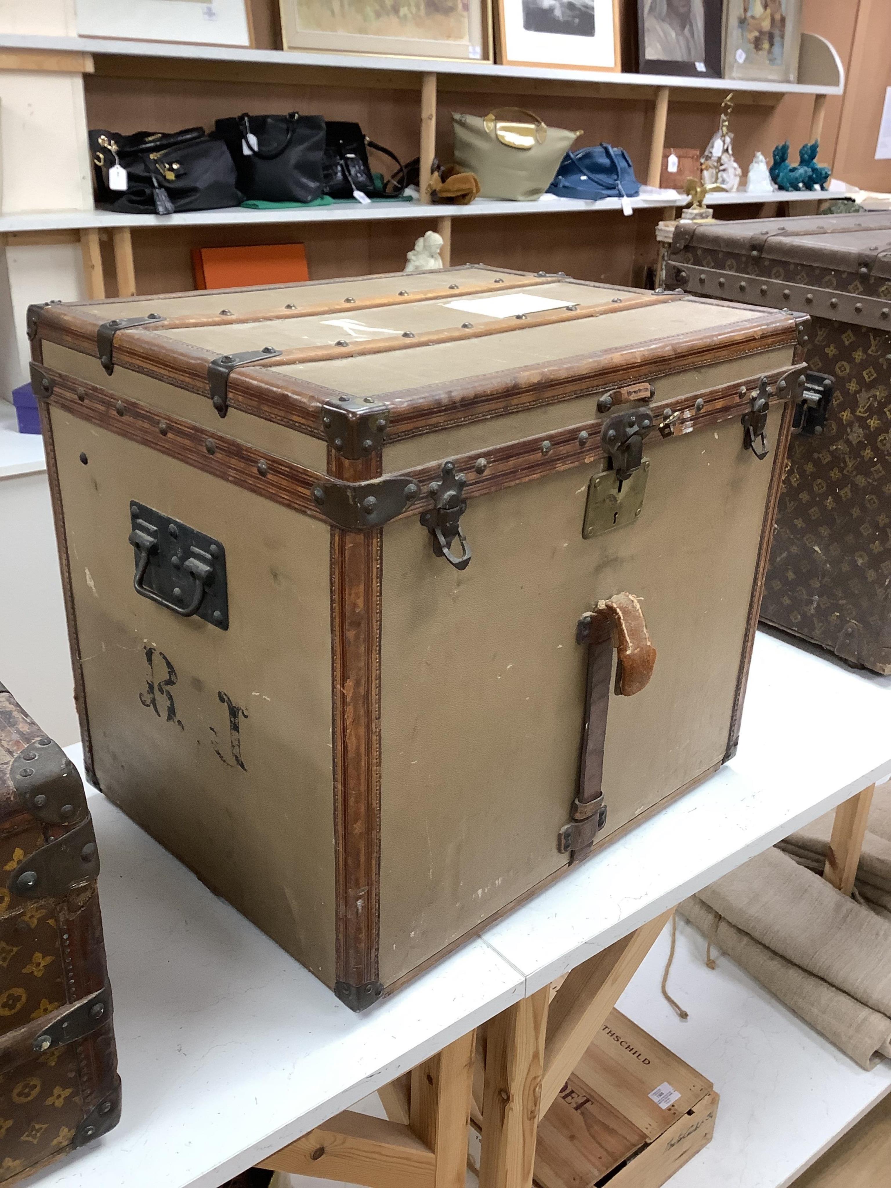 A vintage Louis Vuitton trunk, with brass and leather mounts and studded wooden slats, in plain beige canvas, with label for Paris and London, number 159008, 61cm wide, 48cm deep, 53cm high